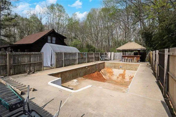 a view of a house with swimming pool and sitting area