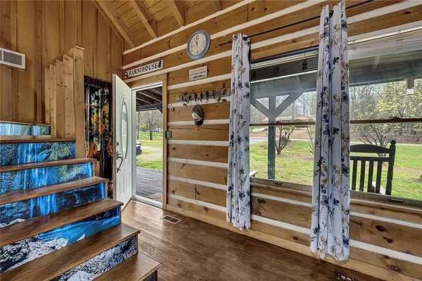 a view of an empty room with wooden floor and windows