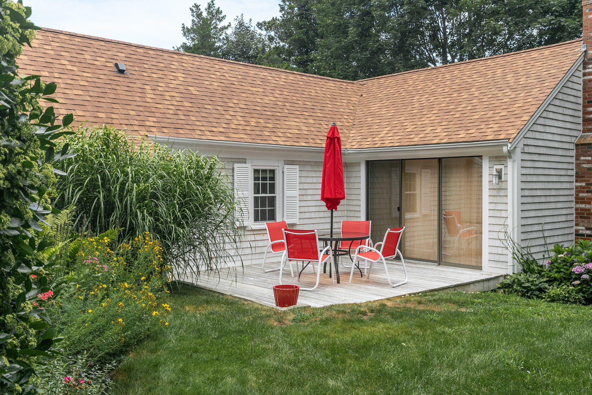 311 Main Street Centerville, MA 02632 - Photo 3 of 45 a view of backyard with table and chairs and potted plants