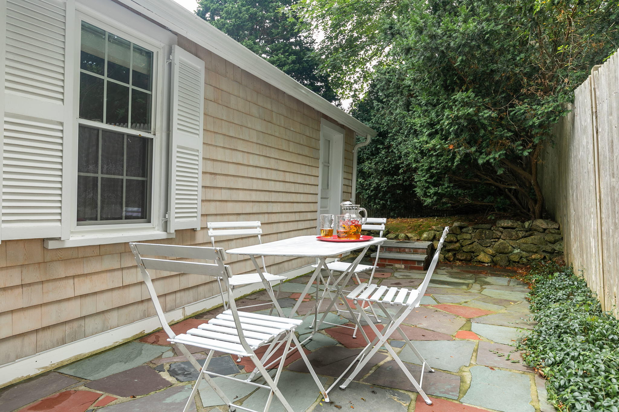 311 Main Street Centerville, MA 02632 - Photo 40 of 45 a patio with table and chairs and potted plants