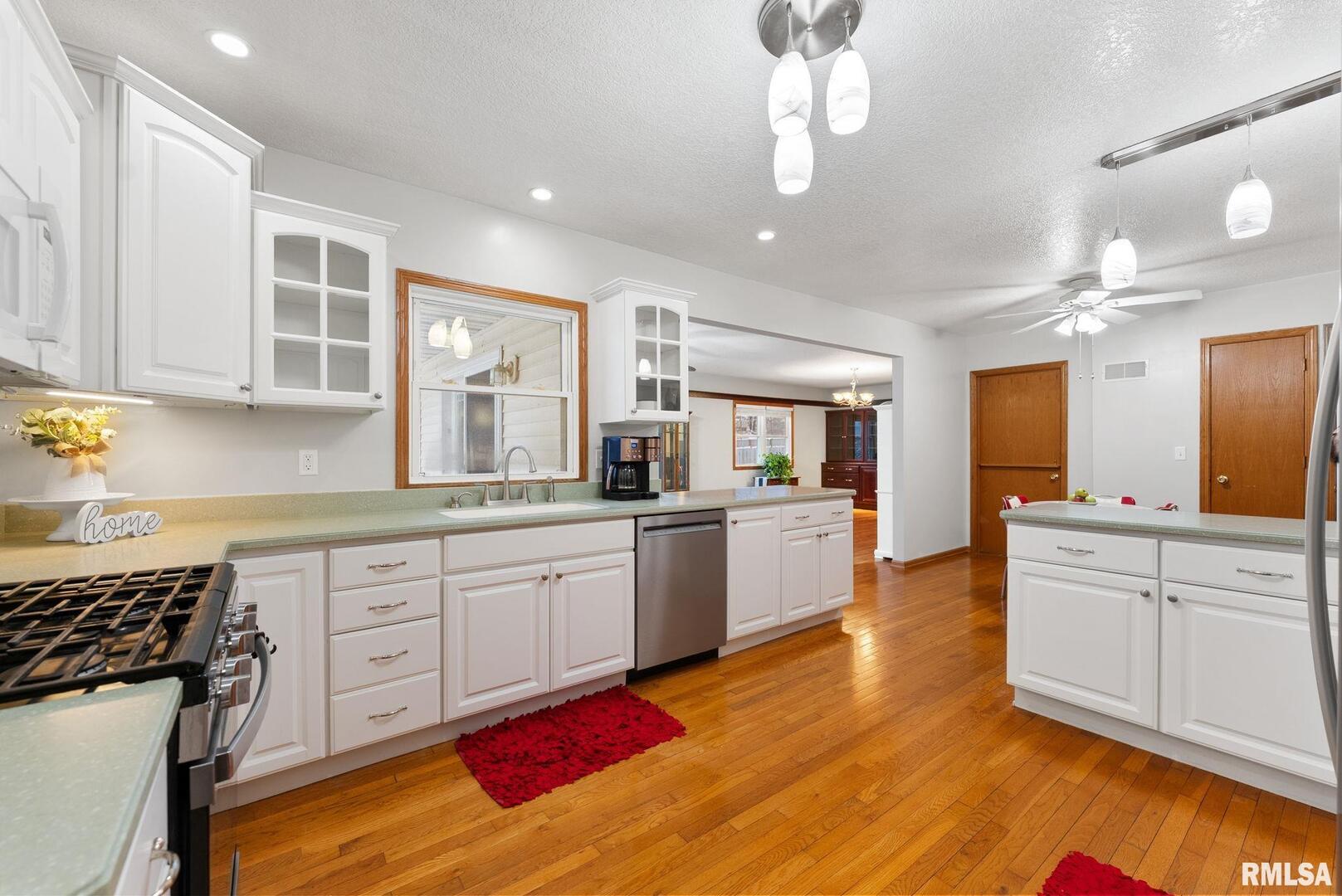 2530 37th Avenue Rock Island, IL 61201 - Photo 9 of 31 a large kitchen with cabinets wooden floor and stainless steel appliances