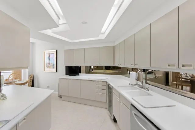 a kitchen with a sink dishwasher and white cabinets