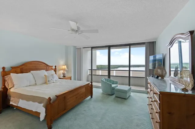 a bedroom with bed and glass walk in closet