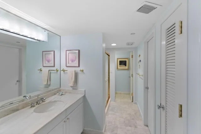 a spacious bathroom with a mirror sink and shower