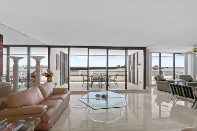 a living room with furniture and floor to ceiling windows