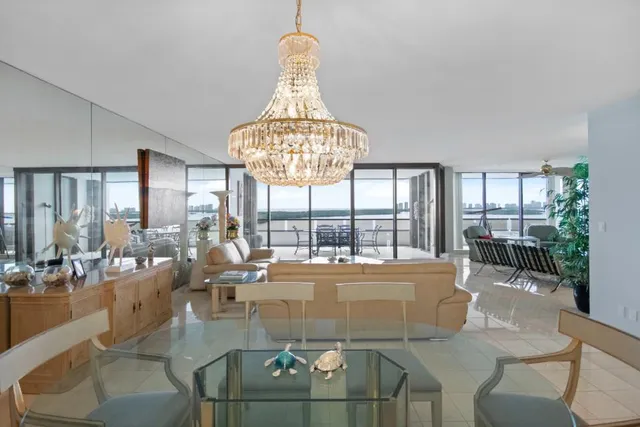 a living room with couches chandelier and a large window