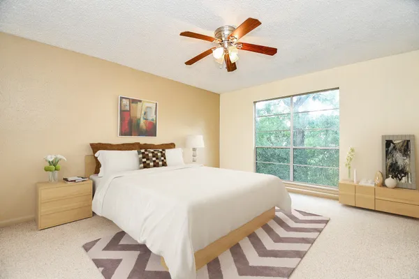 a bedroom with a bed and a large window