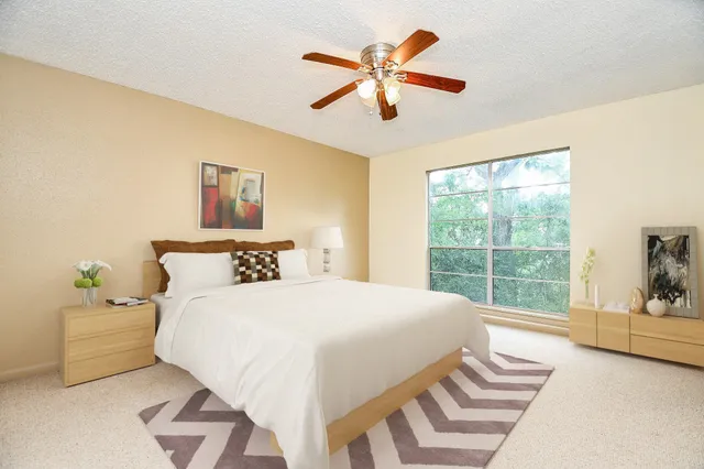 a bedroom with a bed and a large window