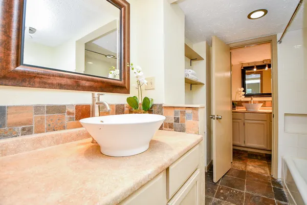 a bathroom with a granite countertop sink and a mirror