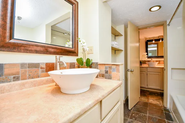 a bathroom with a granite countertop sink and a mirror