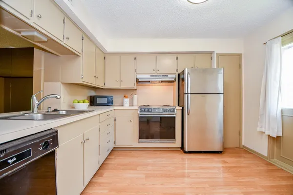 a kitchen with a refrigerator sink and cabinets