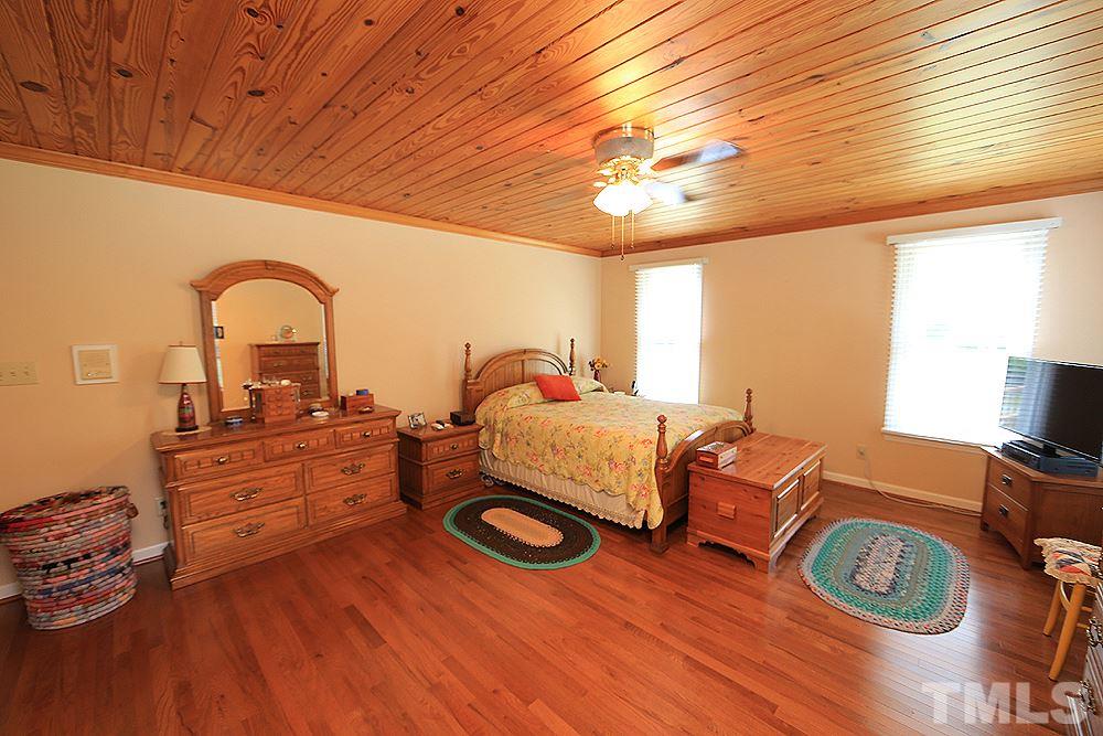 9808 Hampton Road Rougemont, NC 27572 - Photo 14 of 25 a bedroom with furniture and a wooden floor