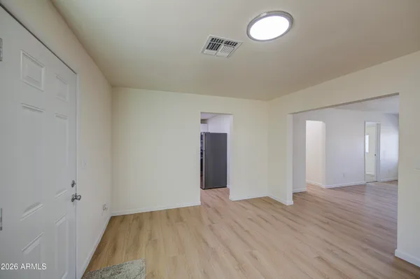 an empty room with wooden floor and mirror