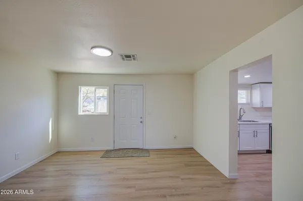 an empty room with wooden floor and windows