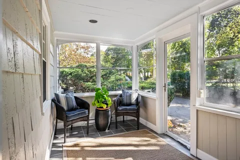 a dining room with furniture and large windows