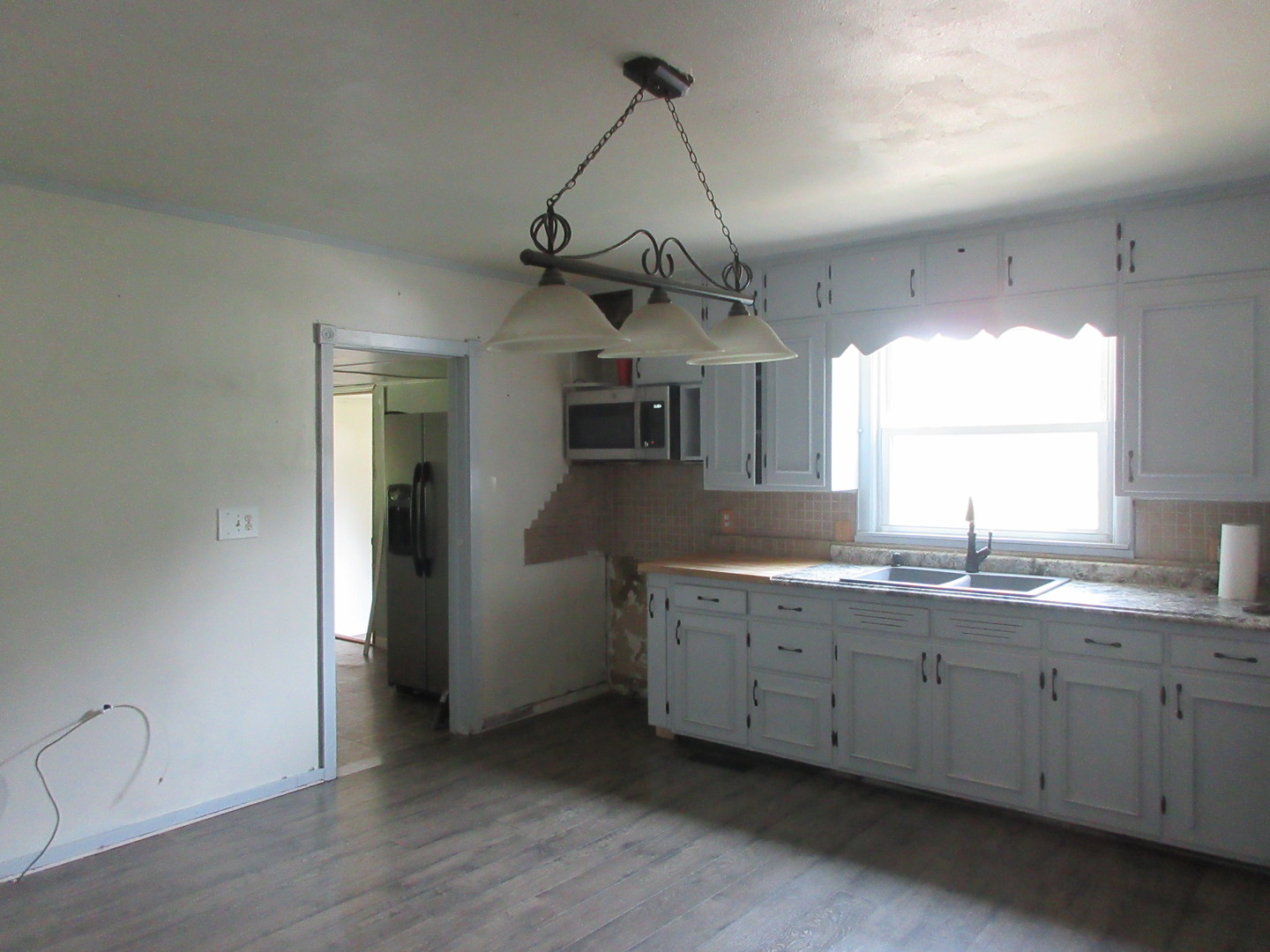 308 West Grove Road Sterling, IL 61081 - Photo 4 of 35 a kitchen with stainless steel appliances granite countertop a sink a window and white wooden cabinets