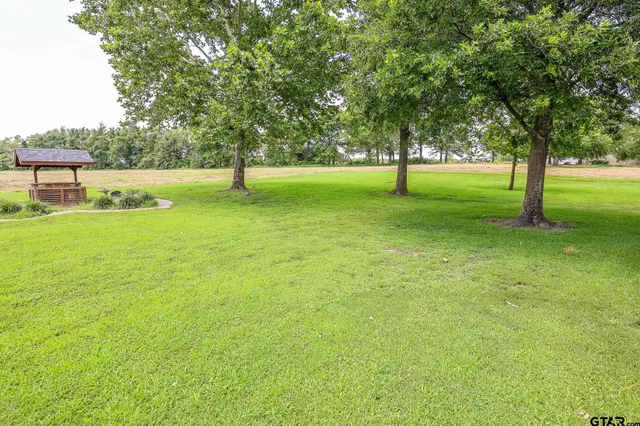 a backyard of a house with lots of green space and fountain