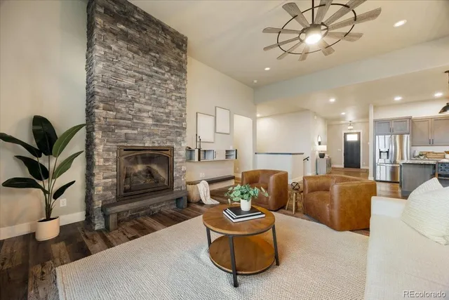 a living room with furniture a fireplace and a chandelier