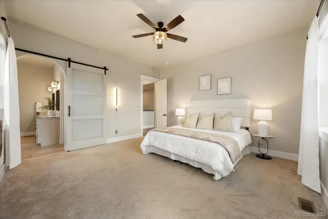 a spacious bedroom with a bed and a ceiling fan