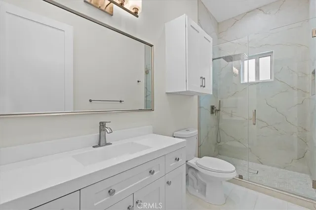 a view of an empty room with wooden floor and windows
