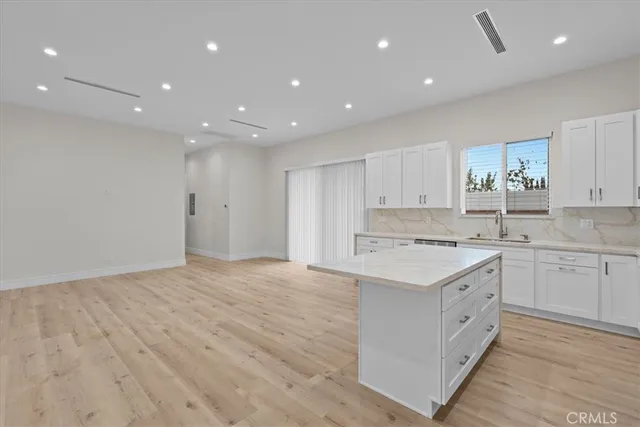 a large kitchen with stainless steel appliances a large counter top and oven