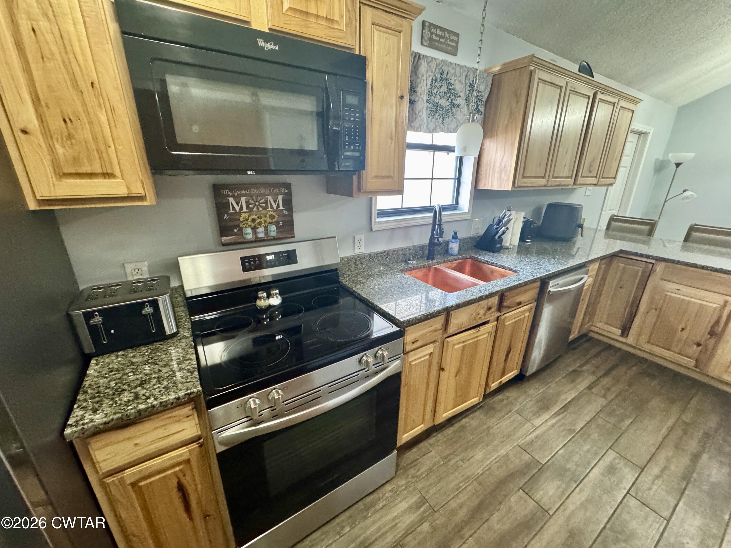 235 Tate Road Dyersburg, TN 38024 - Photo 16 of 34 a kitchen with stainless steel appliances granite countertop a sink stove and cabinets