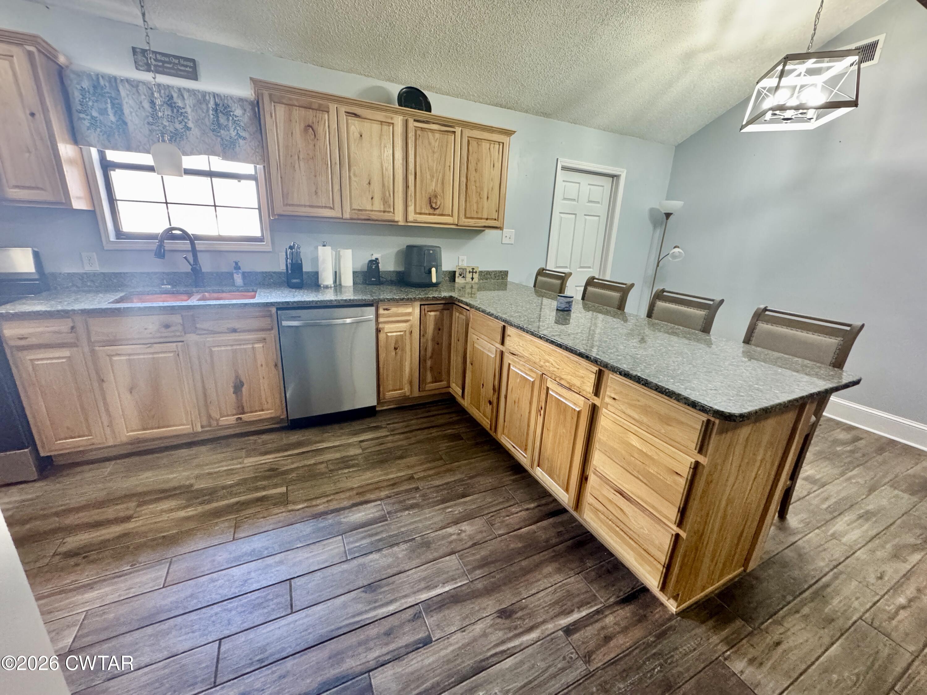 235 Tate Road Dyersburg, TN 38024 - Photo 17 of 34 a kitchen with granite countertop white cabinets and wooden floor
