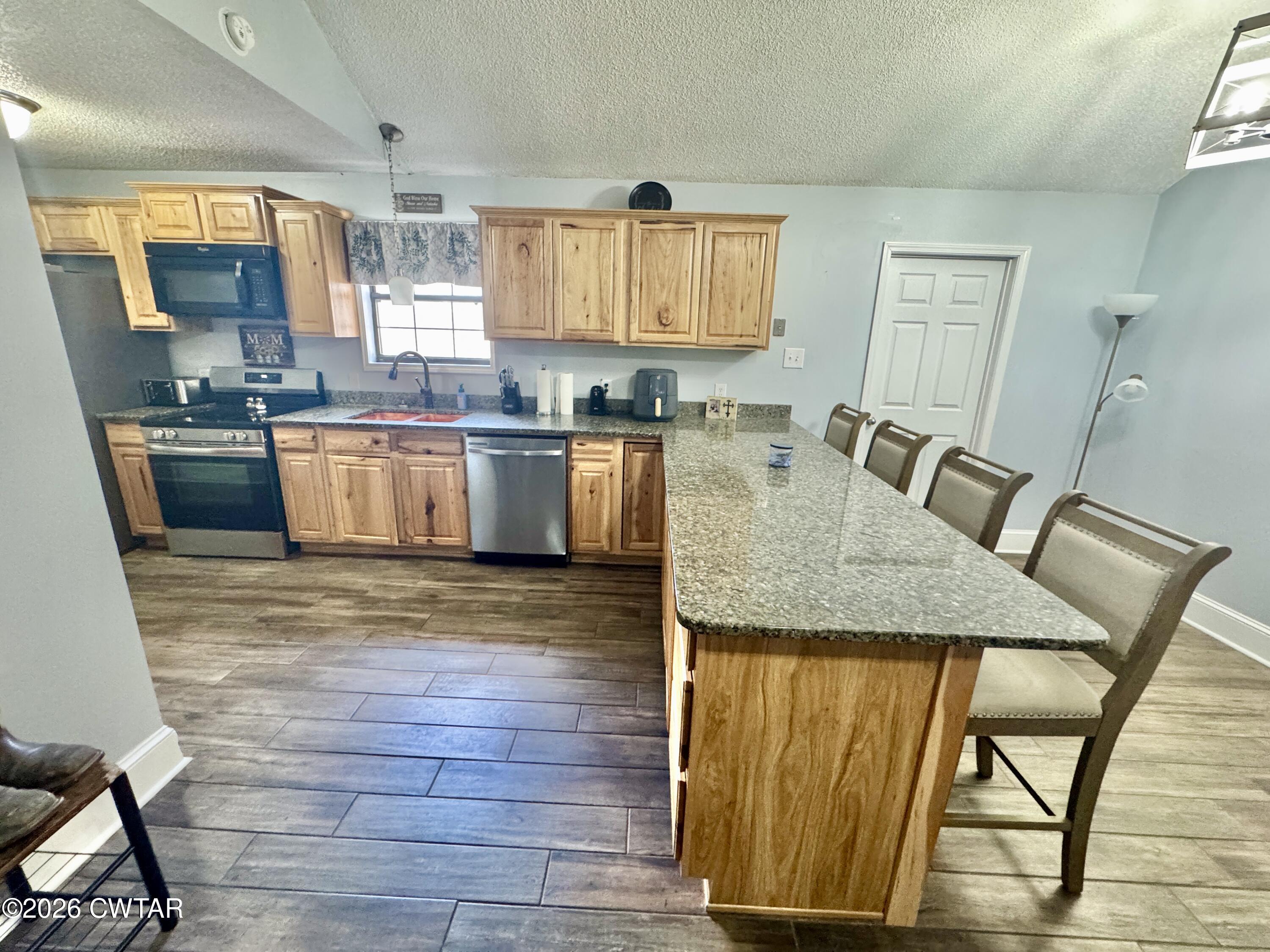 235 Tate Road Dyersburg, TN 38024 - Photo 18 of 34 a kitchen with a wooden floor and a view of living room