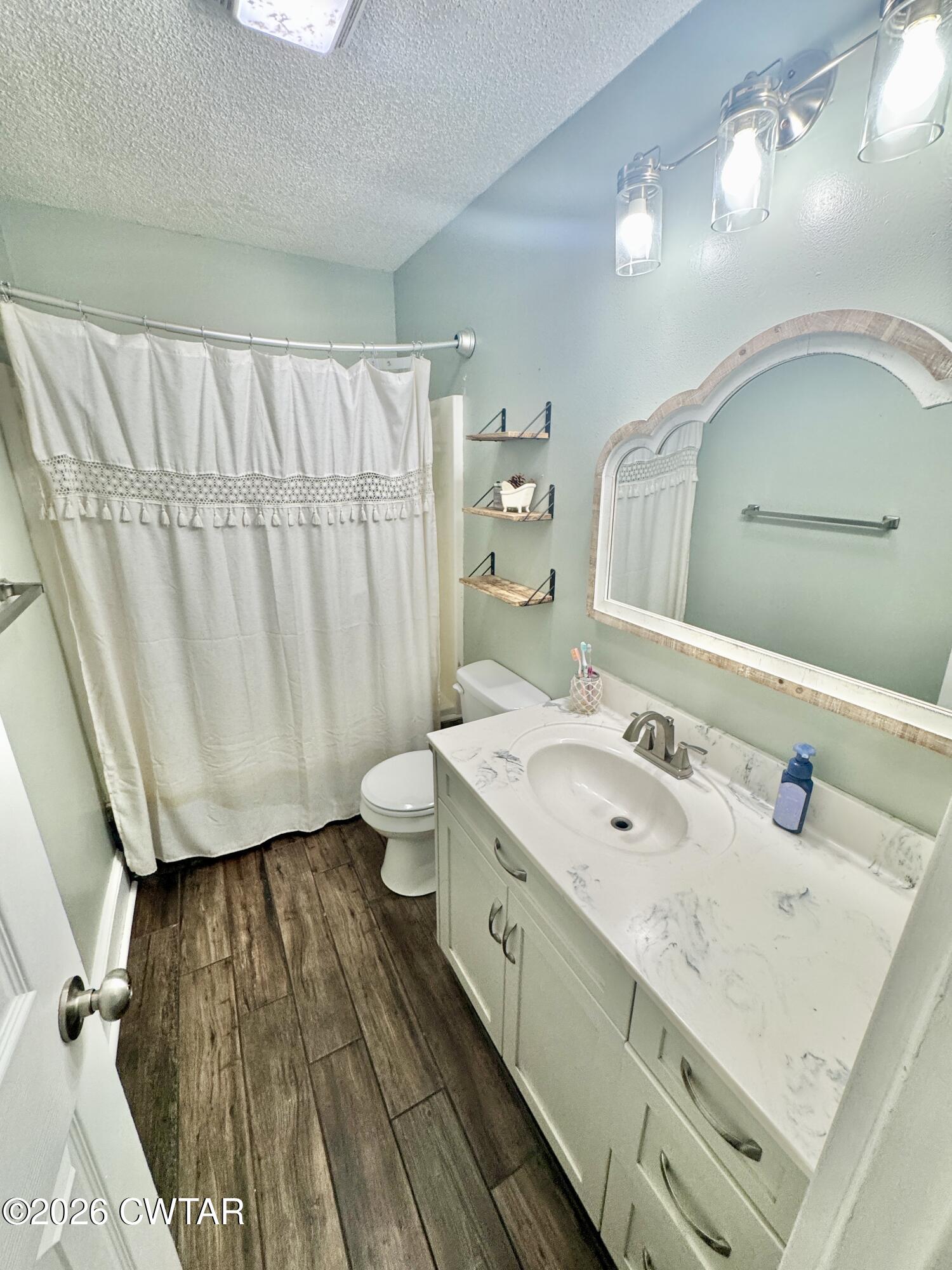 235 Tate Road Dyersburg, TN 38024 - Photo 25 of 34 a bathroom with a double vanity sink a toilet and a mirror