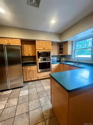 a kitchen with granite countertop a refrigerator and a stove top oven