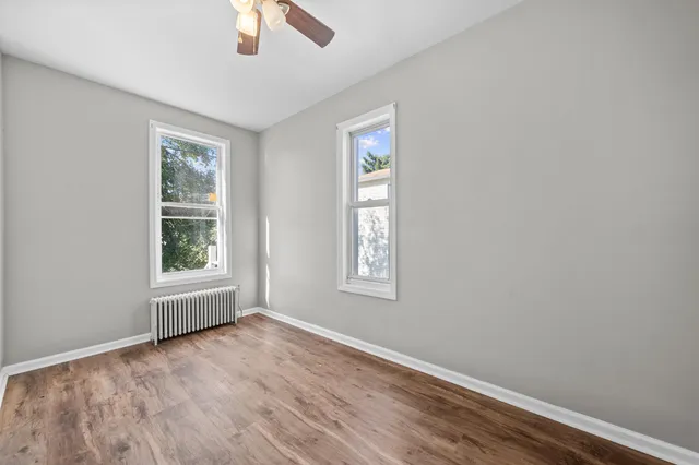 an empty room with a window and wooden floor