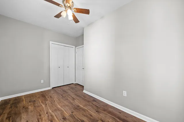 a view of room with hardwood floor and ceiling fan