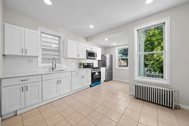 a kitchen with granite countertop white cabinets and appliances