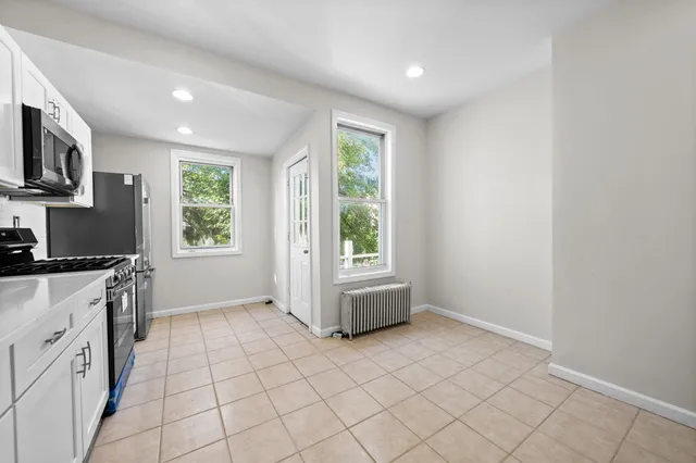 a kitchen with granite countertop a stove a sink and a microwave