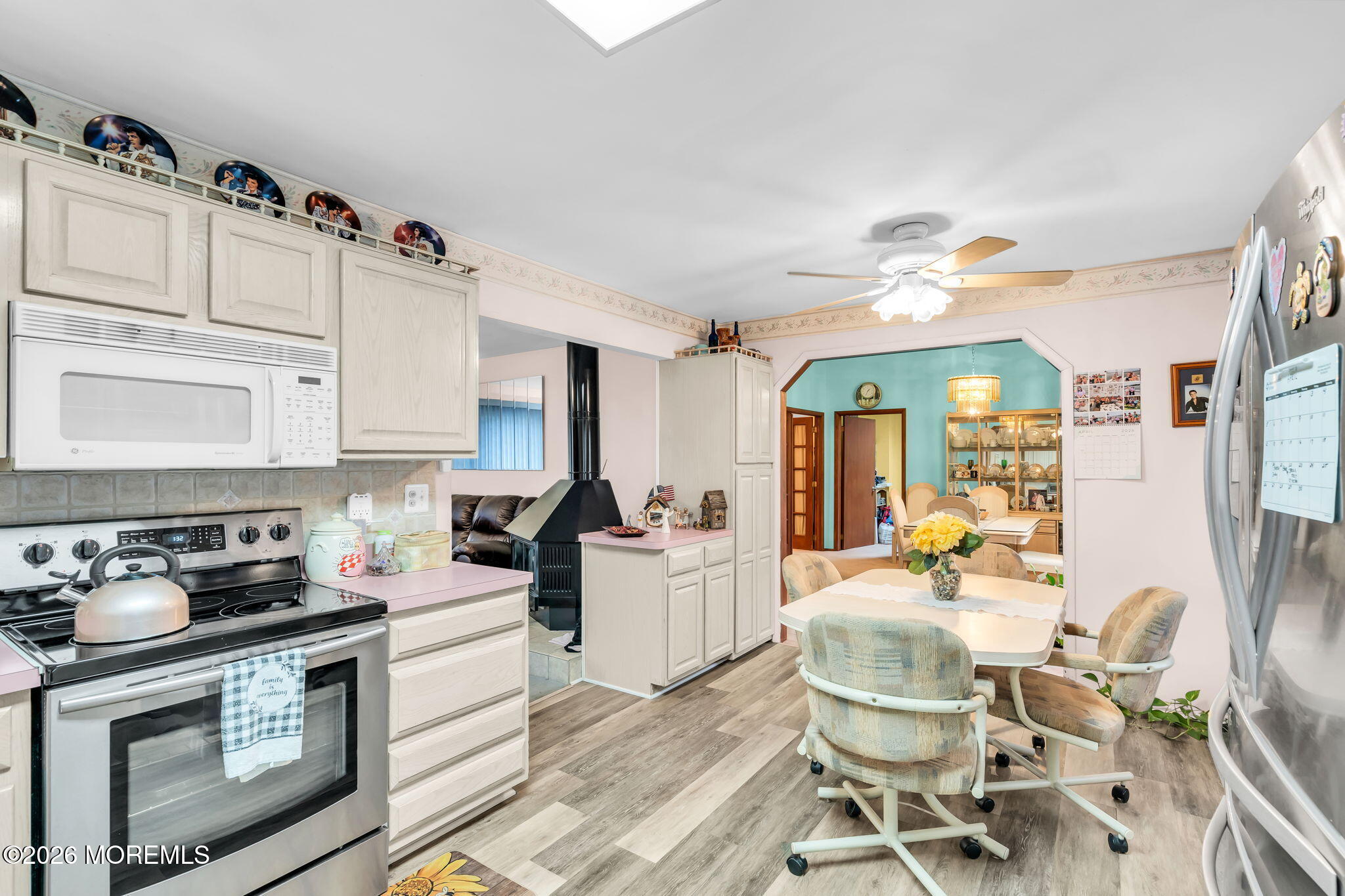 203 Freehold Road Jackson, NJ 08527 - Photo 9 of 33 a kitchen with stainless steel appliances granite countertop a stove a sink dishwasher a dining table and chairs with wooden floor