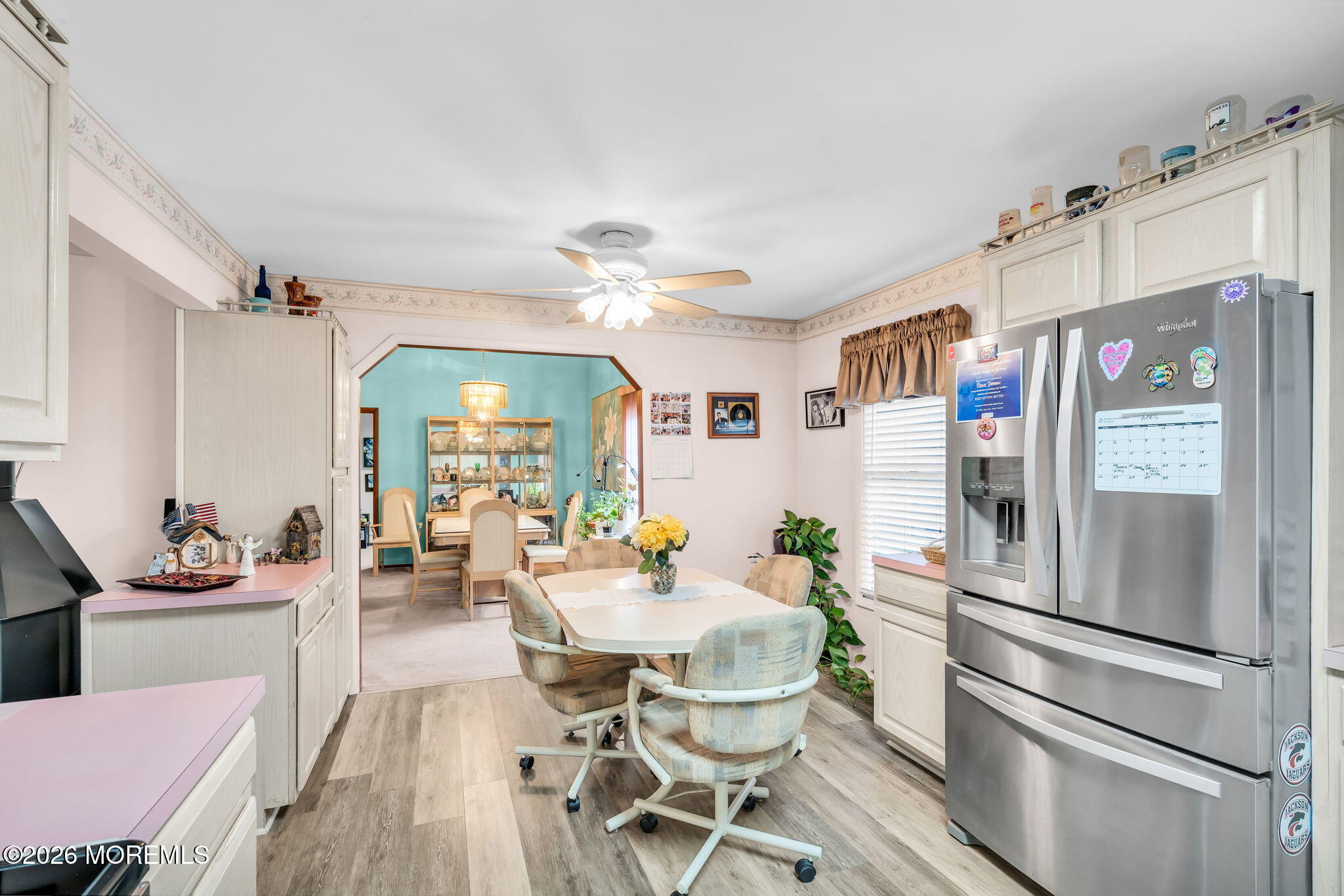 203 Freehold Road Jackson, NJ 08527 - Photo 10 of 33 a kitchen with stainless steel appliances a refrigerator a stove a dining table and chairs with wooden floor