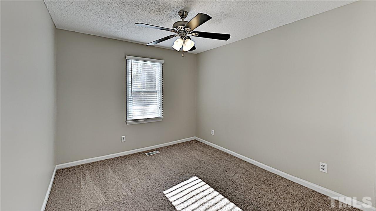 4104 Old Coach Road Raleigh, NC 27616 - Photo 7 of 9 an empty room with a window and a ceiling fan