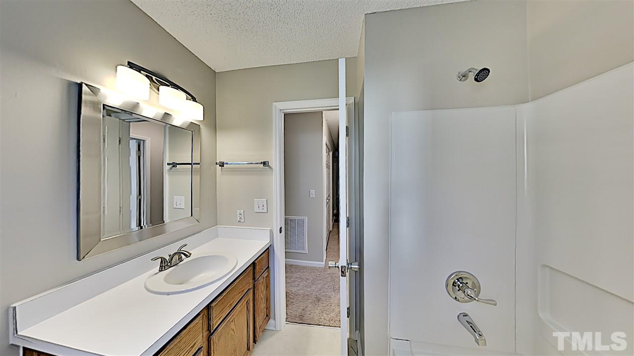 4104 Old Coach Road Raleigh, NC 27616 - Photo 8 of 9 a bathroom with a double vanity sink a mirror and a shower