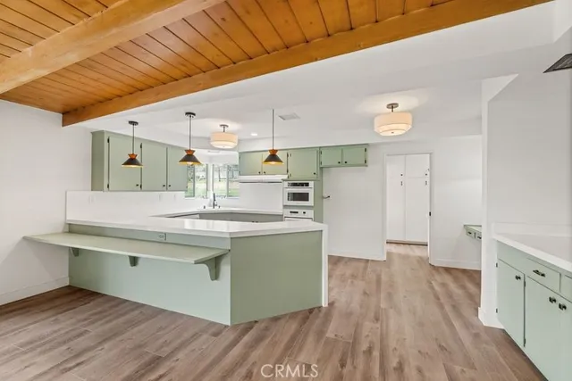 a view of a kitchen with a sink and wooden floor