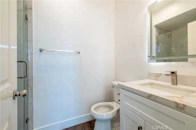 a bathroom with a granite countertop toilet sink and mirror
