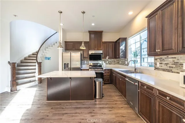 a kitchen with stainless steel appliances kitchen island granite countertop a sink stove and refrigerator