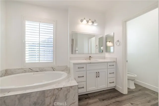 a spacious bathroom with a tub sink and mirror