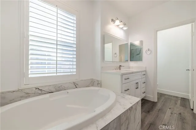 a bathroom with a tub sink and mirror