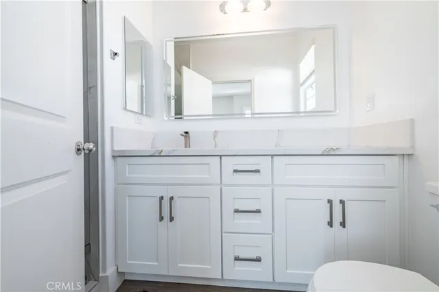 a bathroom with a toilet a sink a mirror and vanity