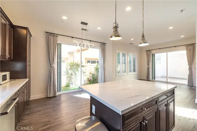 a kitchen with a stove a sink a refrigerator and wooden floor