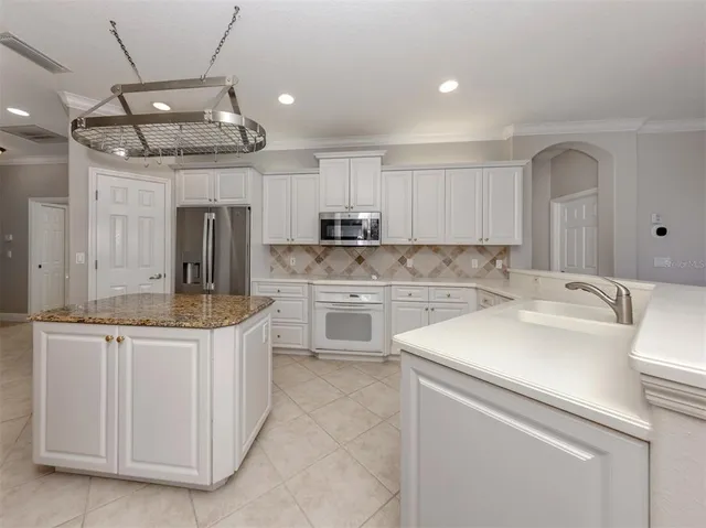a kitchen with cabinets stainless steel appliances and a counter space