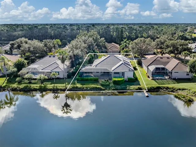 an aerial view of a house with a yard and lake view