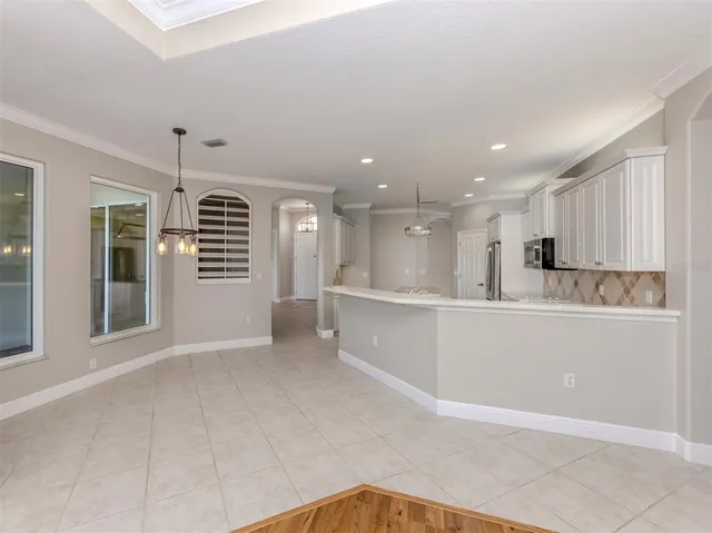 a kitchen that has a lot of white cabinets and stainless steel appliances