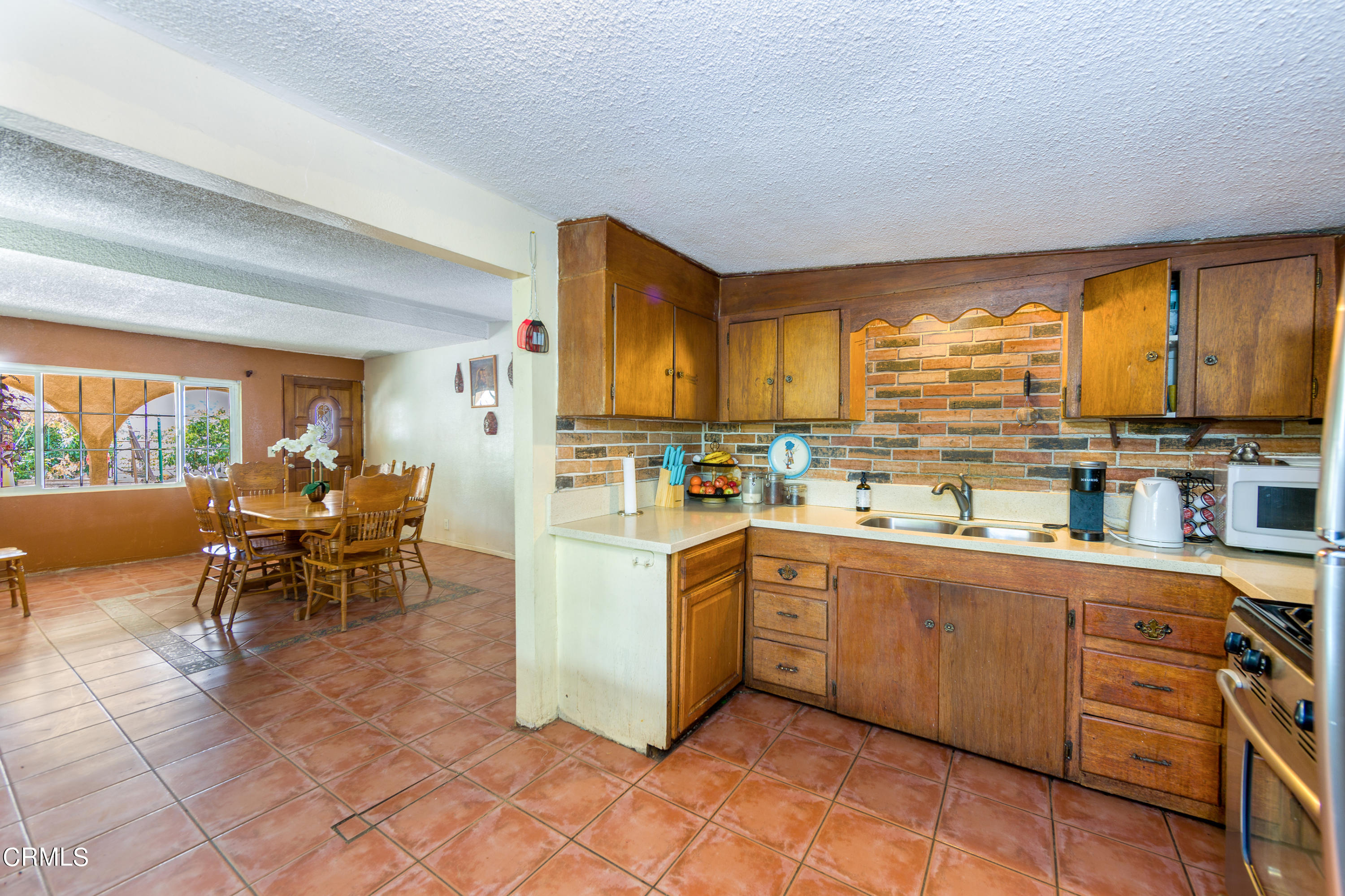 3555 East Telegraph Road Fillmore, CA 93015 - Photo 8 of 21 a kitchen with stainless steel appliances kitchen island granite countertop a stove top oven a sink a dining table and chairs with the large windows