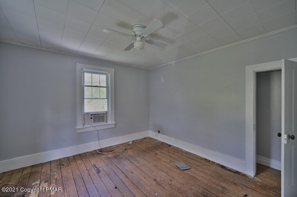 183 Idetown Road Dallas, PA 18612 - Photo 49 of 61 an empty room with wooden floor fan and windows